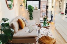 a small boho space with prints, rust touches, lots of potted greenery and string lights all over
