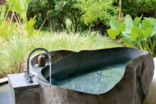 an outdoor stone bathtub with uneven edges will keep you cool outside durign hot days