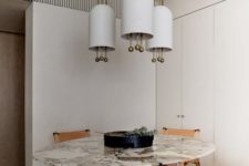 02 The dining space features a unique table with a stone tabletop, leather chairs and a bold chandelier