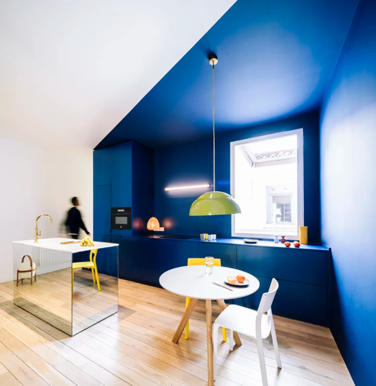 color blocking kitchen design The kitchen features bold color blocking, bright blue and white walls, with a mirror kitchen island and a small breakfast space
