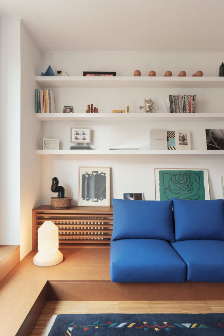 The living room features a platform sofa and some built-in shelves over it