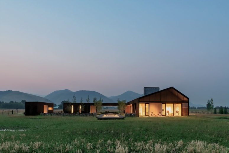 The building has two separate sections connected by the same roof and a beautiful landscape around