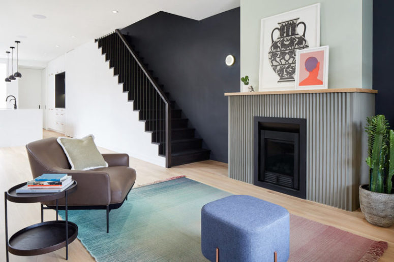 The living room is represented with a grene fireplace, comfy mid century modenr furniture and a gradient rug The living room is represented with a grene fireplace, comfy mid-century modenr furniture and a gradient rug