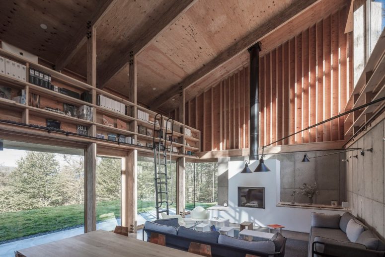 The lower part of the house is a giant open layout with a dining, living room and a kitchen plus bookshelves attached over the glazing