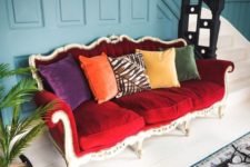 03 a bright eclectic entryway finished off with a bold vintage red sofa and colorful pillows