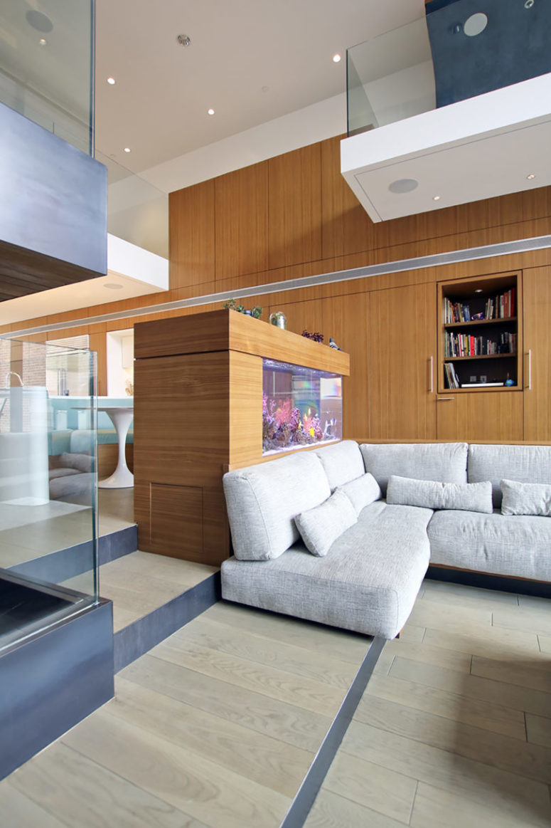 An aquarium works as an eye-catchy space divider, it separates the dining and living room