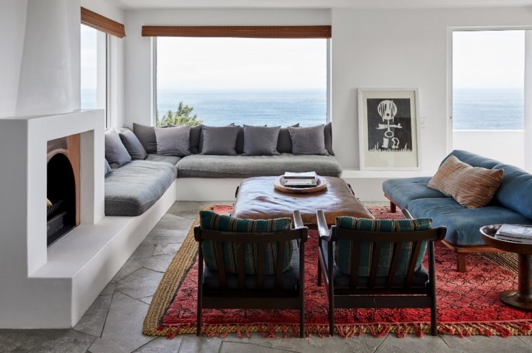 The living room decor continues the outdoor spaces with the same furniture, there's a fireplace and cool art