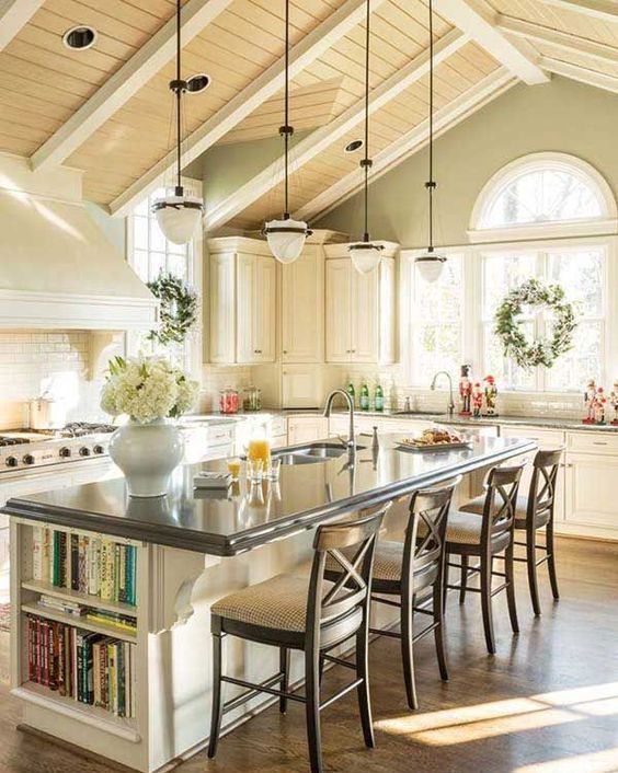 a white farmhouse kitchen with a large kitchen island that features storage and a seating space to eat here