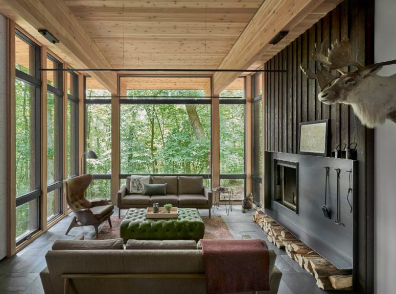 Another living room is done with neutral elegant furniture, a fireplace and full glazing to enjoy the views Another living room is done with neutral elegant furniture, a fireplace and full glazing to enjoy the views