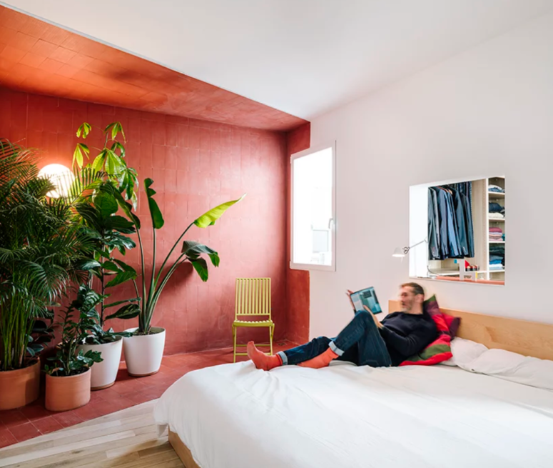 a cool color block bedroom design This bright red zone features lots of potted plants, it's like a small orangery, and there's a window to the closet