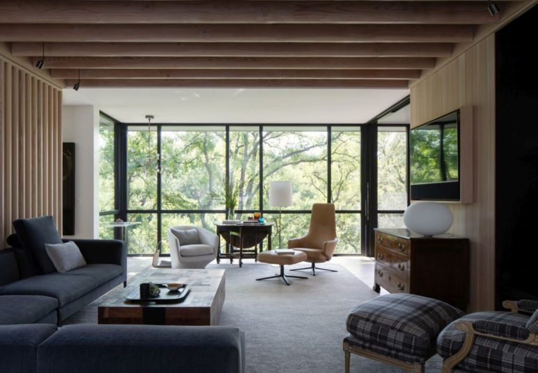 Vast glazing invites outdoors inside and connects the interior spaces with nature, the furniture is modern and chic