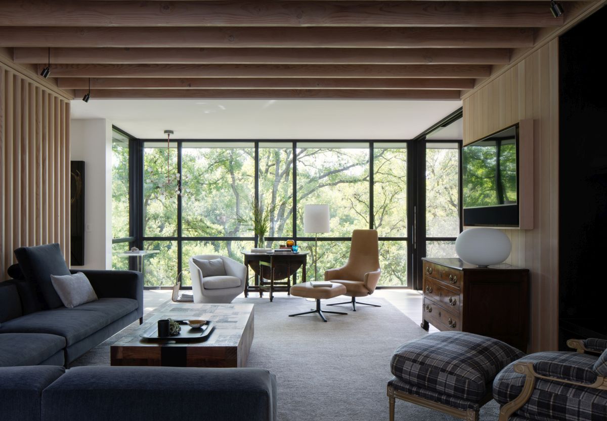 Vast glazing invites outdoors inside and connects the interior spaces with nature, the furniture is modern and chic