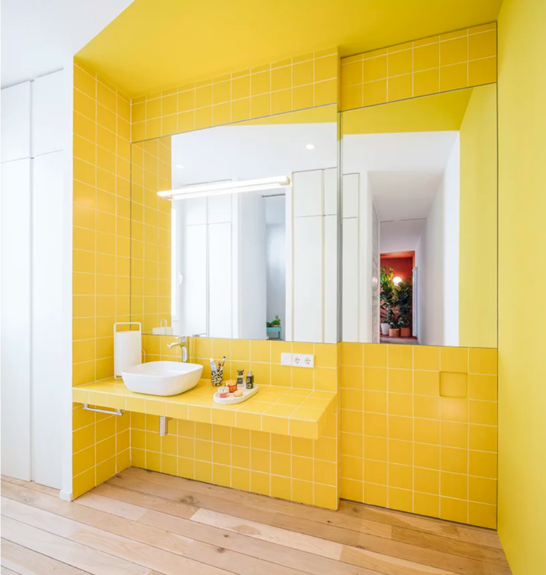color blocking works awesome in a bathroom The color block bathroom is done with bright yellow tiles that also form a vanity and there are two large mirrors