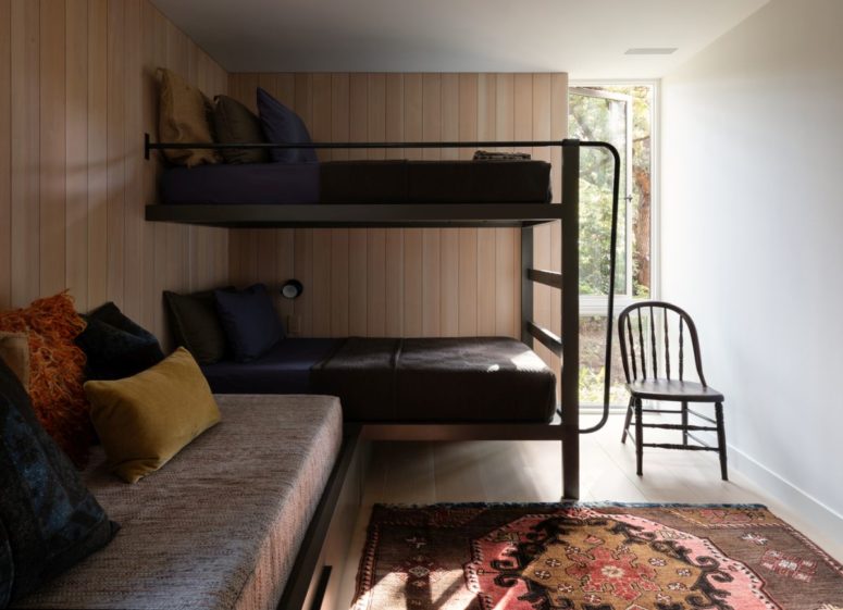 There's a guest bedroom with bunk beds and a sofa with pillows plus a bright rug
