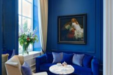 07 a refined yet tiny living room with blueberry blue walls and a bright blue sofa for a bold touch