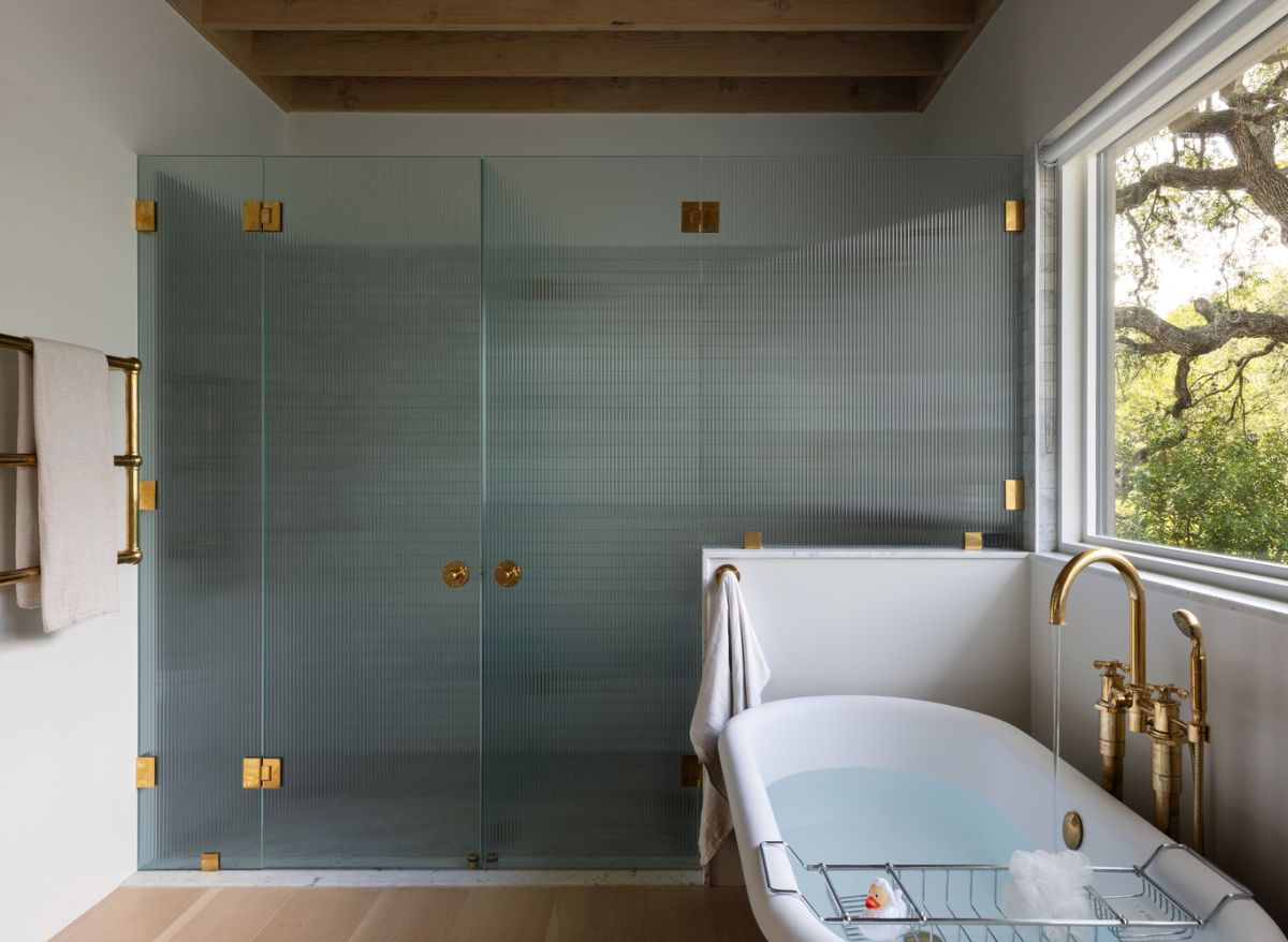 a walk in shower surrounded by textured glass