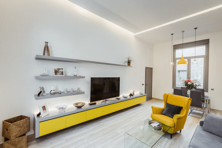 The contemporary living room is done with bright and neutral furniture, with a combo of yellow and grey