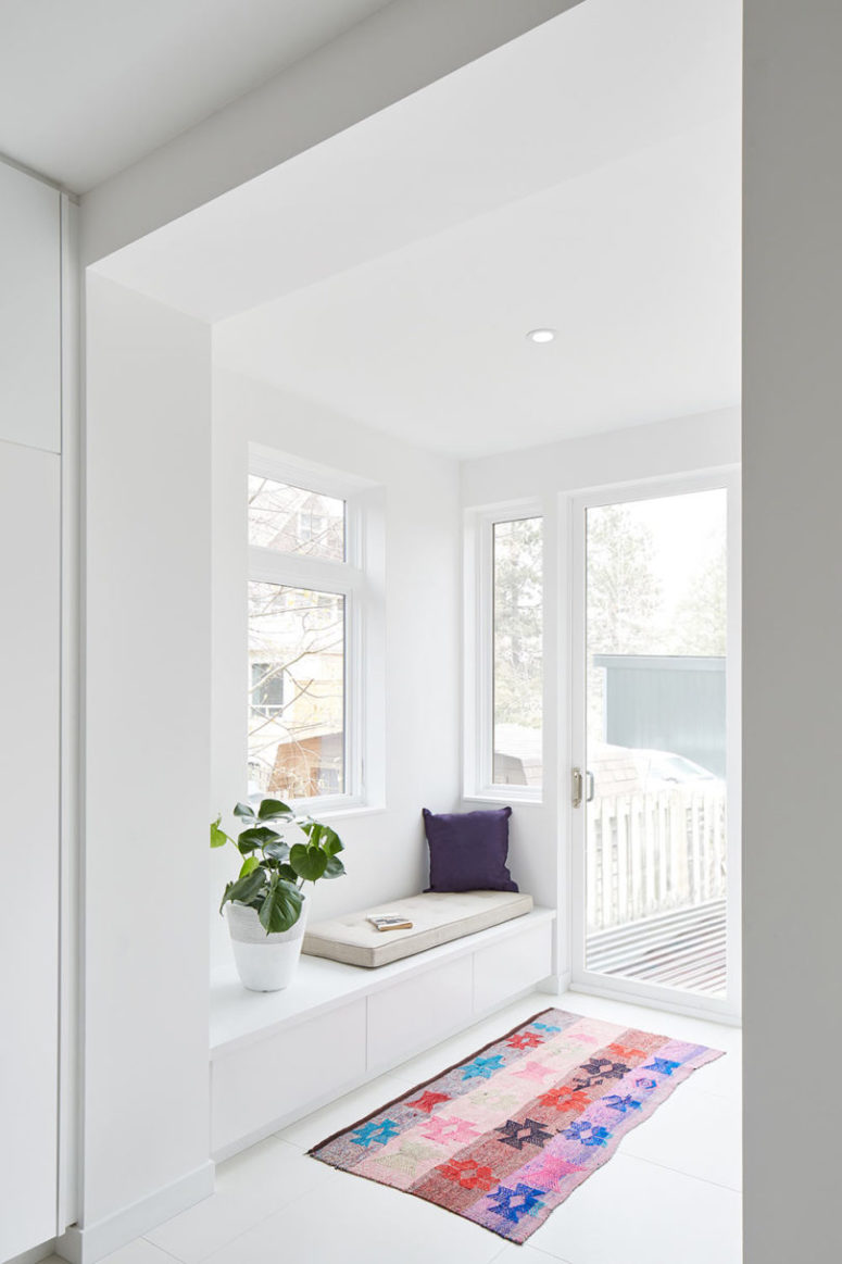A small veranda with a reading nook, storage drawers is done with many windows to bring light in