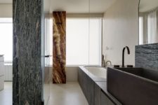 09 The bathroom is done with a tub covered with stone and a stone stink plus gorgeous marble pillars