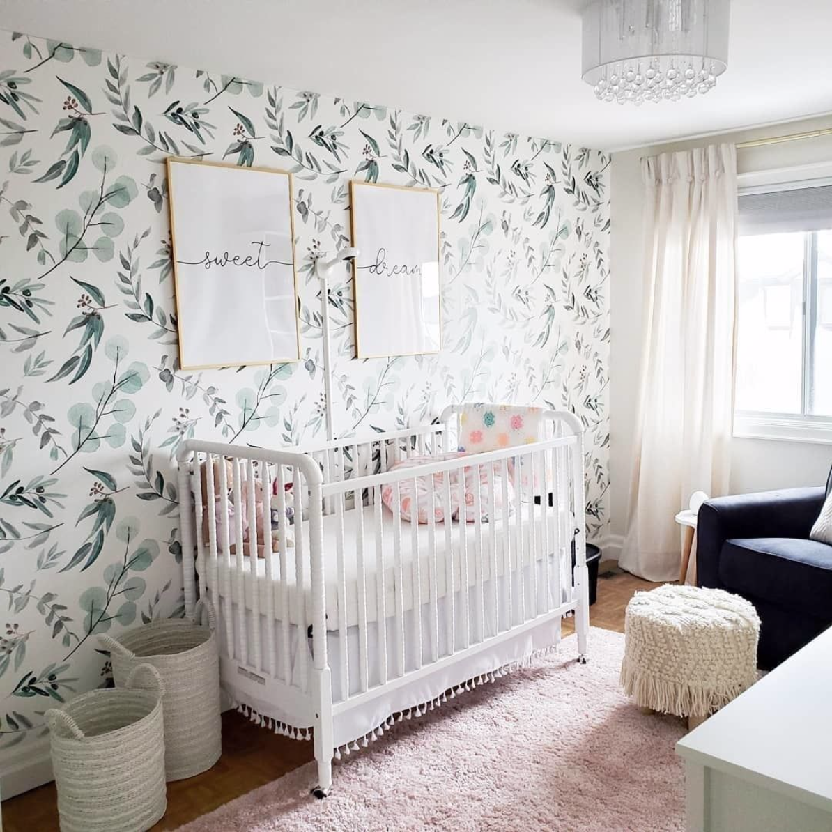 a welcoming and cool nurseyr in light shades and pastels plus a delicate leaf print accent wall