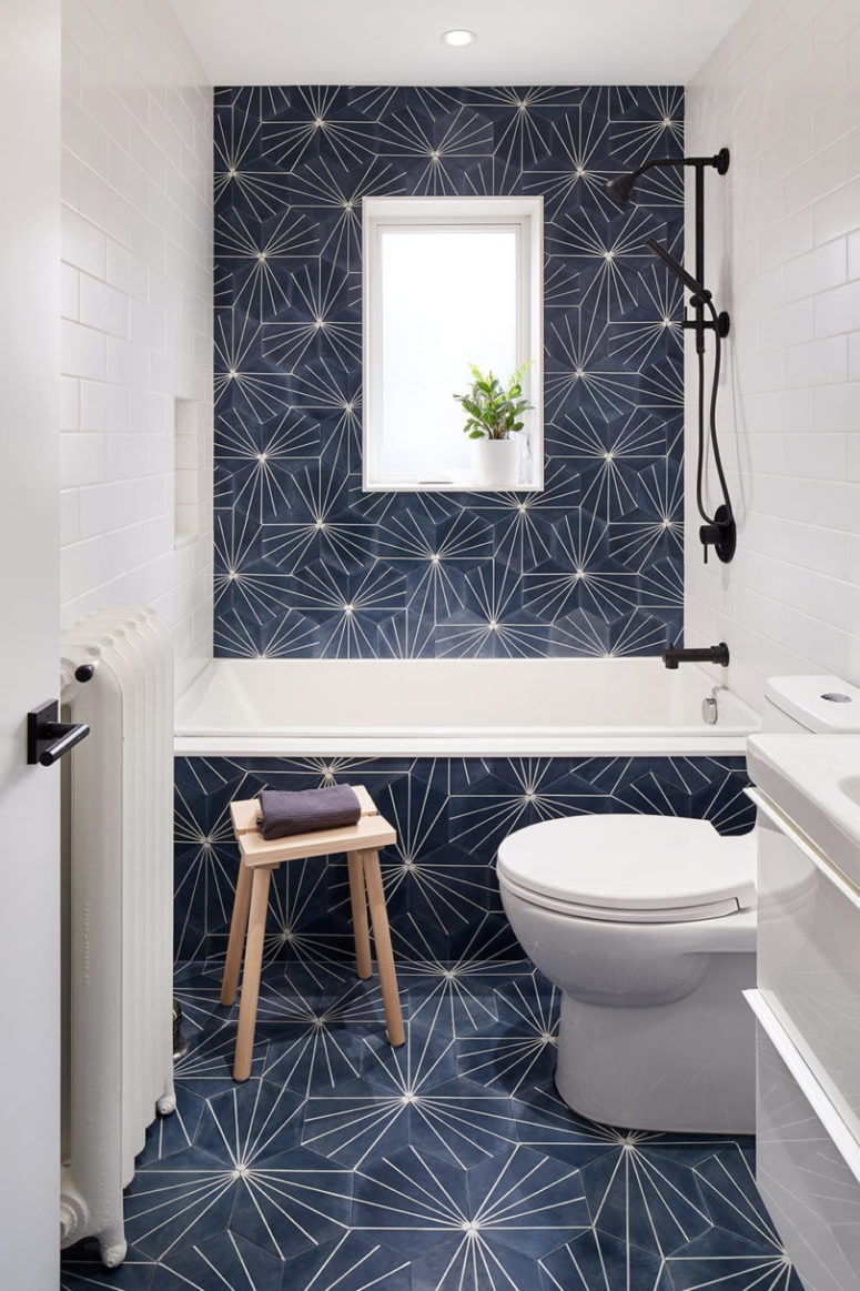 The bathroom is clad with printed navy tiles paired with white subway ones, there's a window for light The bathroom is clad with printed navy tiles paired with white subway ones, there's a window for light