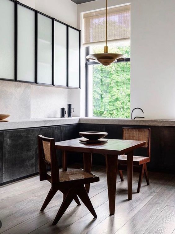 The dining space is located in the kitchen, it's done with wicker chairs and a cool metal pendant lamp