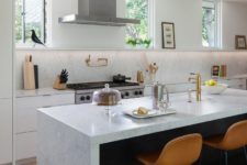 12 The kitchen is neutral and very airy, with stone countertops, leather stools and touches of gold here and there
