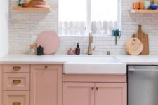16 a small kitchen done with pink cabinets, a bright printed rug and neutrals to create a contrast