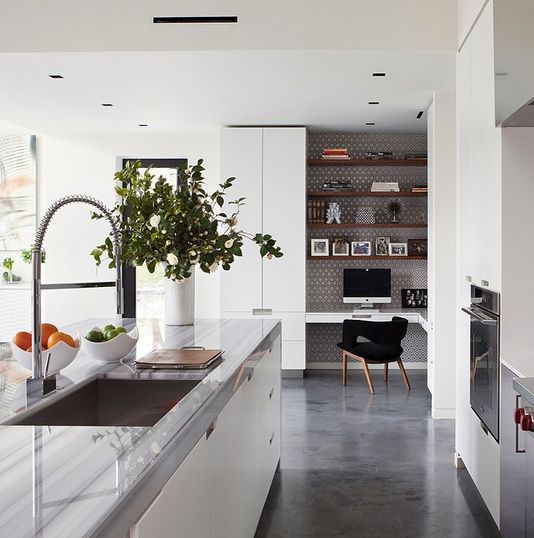 a built-in workplace nook within the nook is highlighted with printed wallpaper, a nook floating desk and a black chair