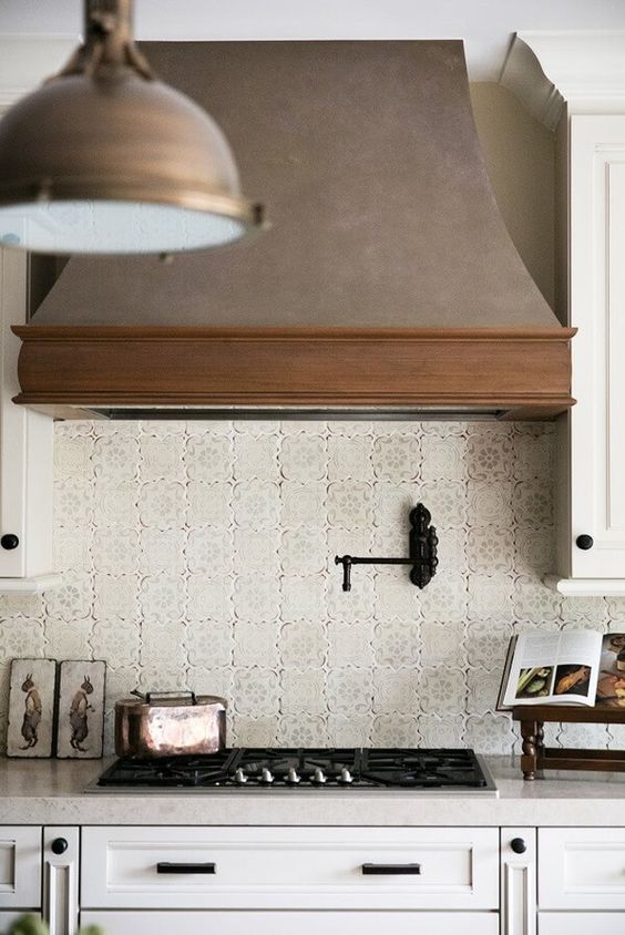 a light farmhouse kitchen with a vintage wooden hood that adds texture, interest and a cool look to the space