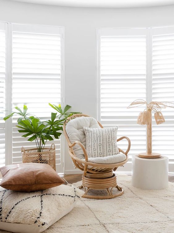 a neutral interior with a rattan swivel rocker chair with neutral upholstery and chairs