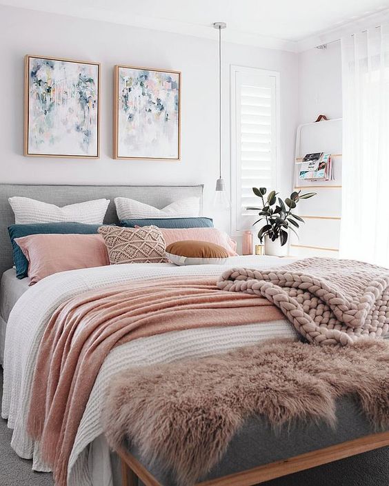 an airy contemporary bedroom with a layered bed and an arrangement of colorful throw pillows