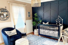 22 an elegant nursery with a black 3D geometry accent wall, a matching crib and a navy chair to create a cohesive look