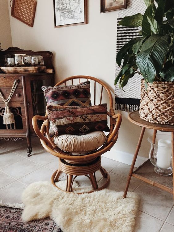a rattan swivel rocker chair with boho pillows and rugs is a cool idea to finish off a boho space