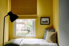 24 a small reading nook with bright yellow walls that define this nook in the grey space