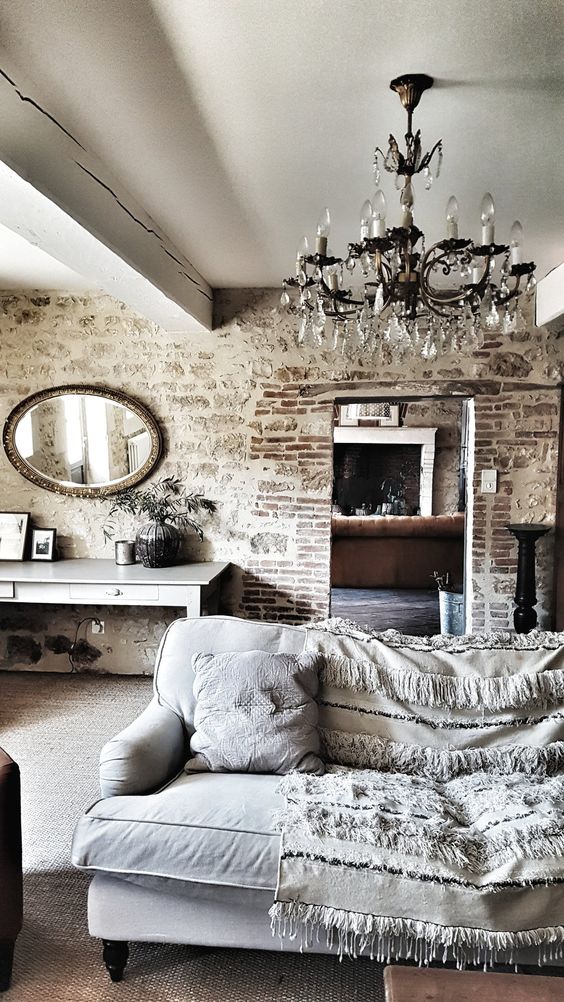 an industrial meets contemporary space softened with a vintage mirror and chandelier for a refined look