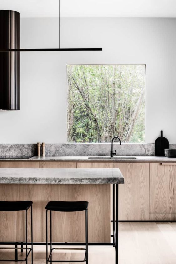 a biophilic kitchen with a window for a view, natural wooden cabinets, stone countertops for a natural feel