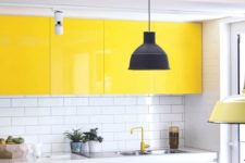 a bold contemporary kitchen done in white, with bright yellow upper cabinets, a wooden countertop and a white subway tile backsplash