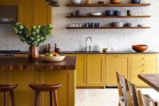 a bold kitchen with mustard cabinets, wooden countertops, a white tile backsplash and touches of wood here and there
