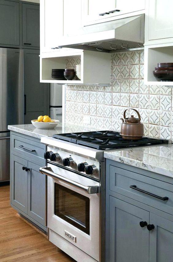 a chic blue and white kitchen with a grey countertop and a grey tiel backsplash looks neat, stylish and timeless