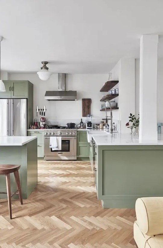 a chic contemporary kitchen in sage green and white, with dark wooden touches and white countertops is very welcoming