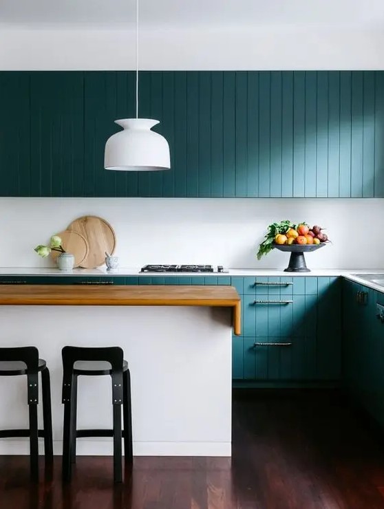 a chic contemporary teal kitchen with beadboard cabinets, a white sleek backsplash and countertops is amazing