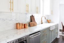 a chic kitchen with pale green and white cabinets, gold handles and white stone countertops and backsplashes for a fresh feel