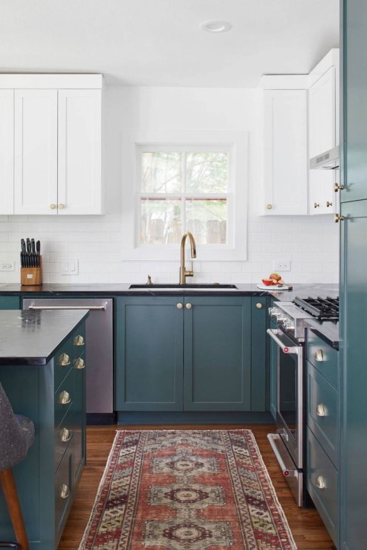 a chic two-tone kitchen with teal and white shaker style cabinets, a white tile backsplash and a bold rug