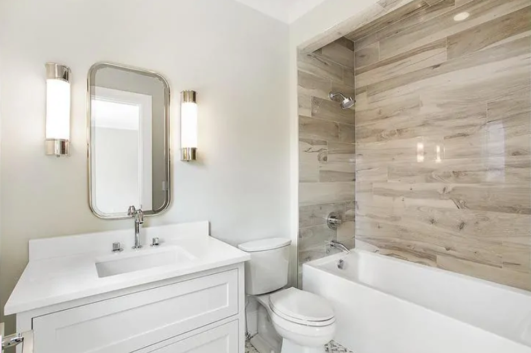 a contemporary bathroom done in white and with wood look tiles over the bathtub to highlight this zone