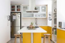 a contemporary kitchen done with sunny yellow and white cabinets, with white countertops and a mosaic floor looks cool