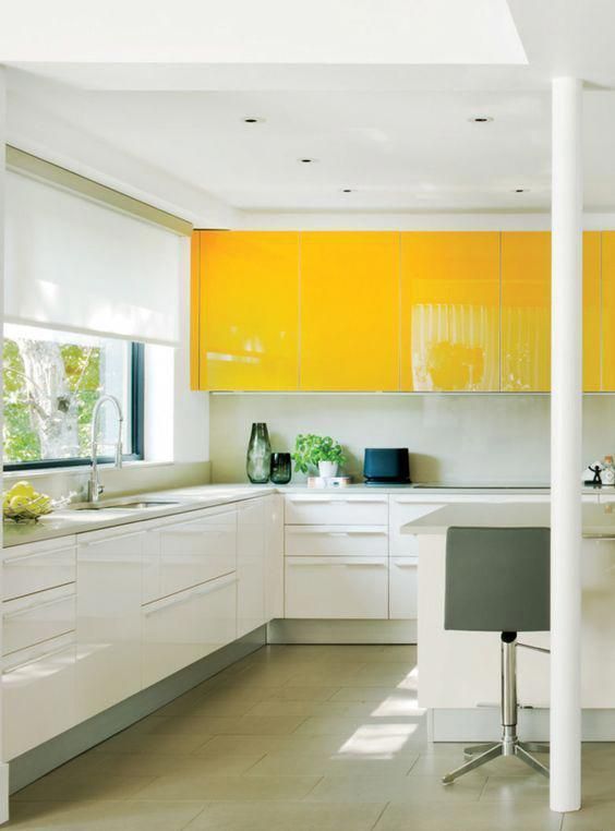 a contemporary kitchen with upper bright yellow cabinets, white ones and a white backsplash looks ultra bold