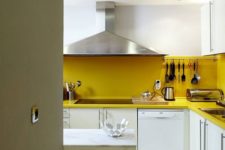 a contemporary white kitchen made bold with a yellow backsplash and countertops plus staineless stele appliances