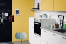 a contemproary kitchen done in mustard and white, with touches of black for some drama