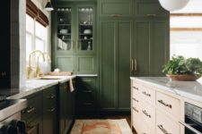 a dark green kitchen, a light colored wood kitchen island, white stone countertops and gold touches for a mid-century modern feel